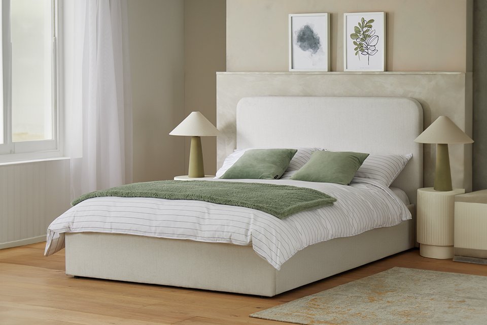 Habitat Chadwell Double End Lift Ottoman Bed in a bedroom with white bedding and green cushions on it.